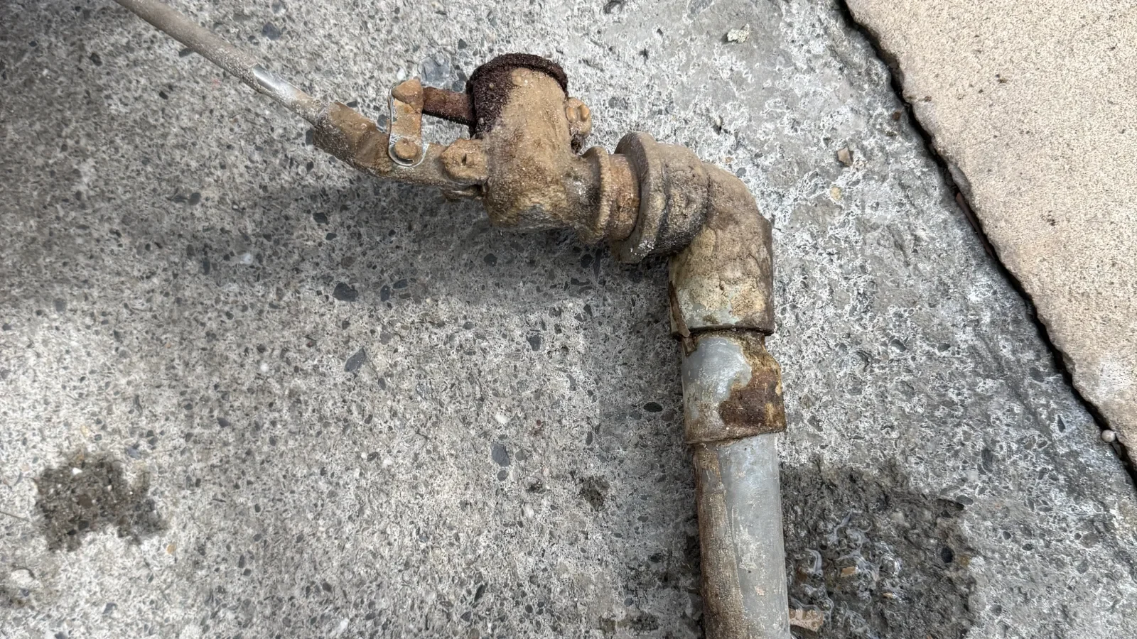 EC 值偏高的水源會在整條水路上留下痕跡:這組拆下來的球閥與管件,外表已經看不出金屬原色,閥體與接頭被一層厚厚的礦物垢包住,閥門也早就轉不動了。水質數據平常看不見,但它會用這種方式,一件一件寫在你的設備上。